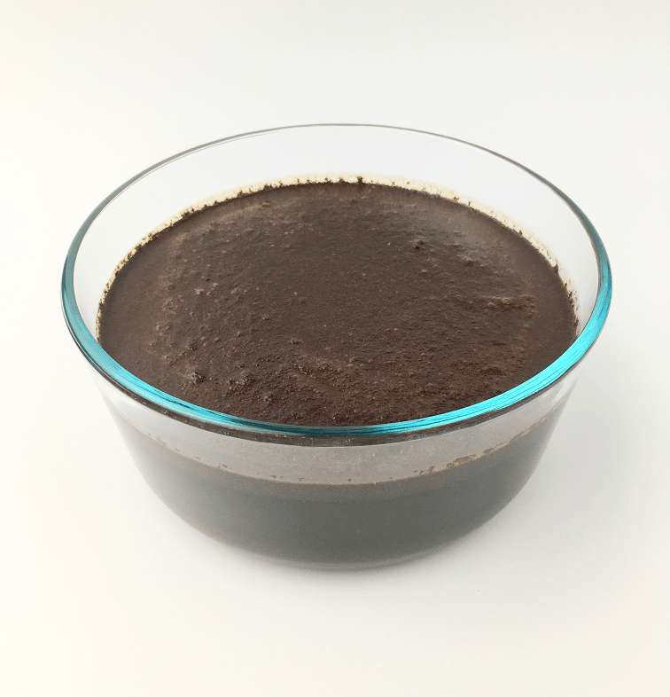 Large glass container with coffee grounds mixed with water