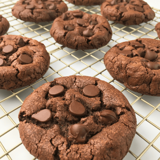 Close up image of double chocolate chip cookies on a cooling rack