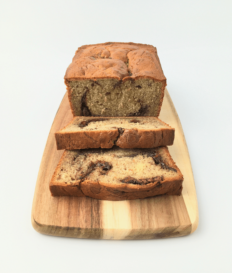 Nutella swirl banana bread loaf on a wooden cutting board with slices showing dollops of Nutella in the middle of the slice