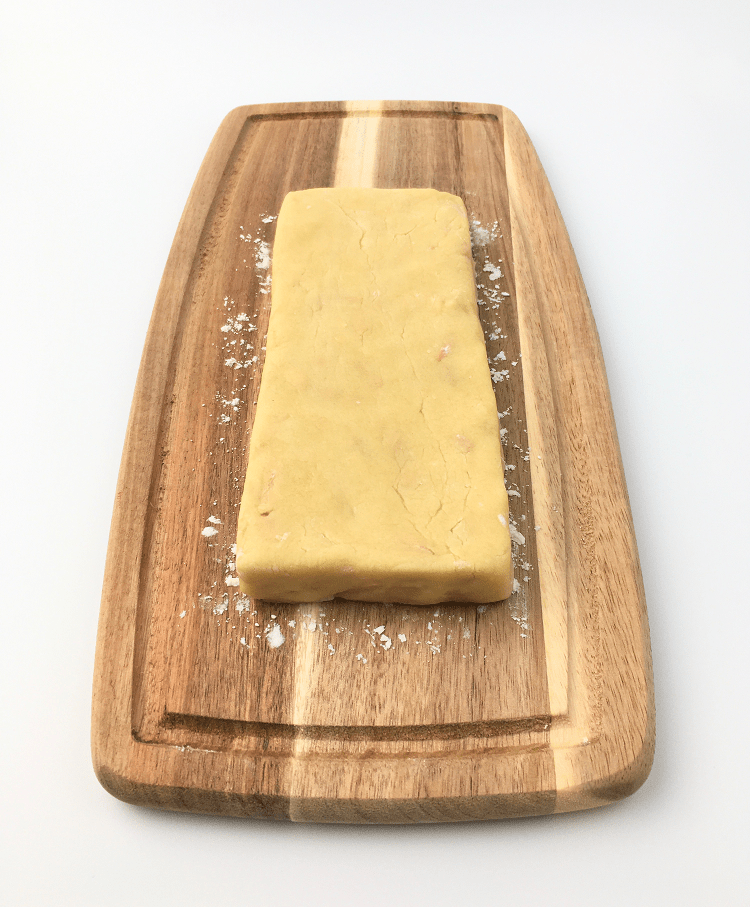 Vanilla almond biscotti dough formed into a rectangle on a cutting board