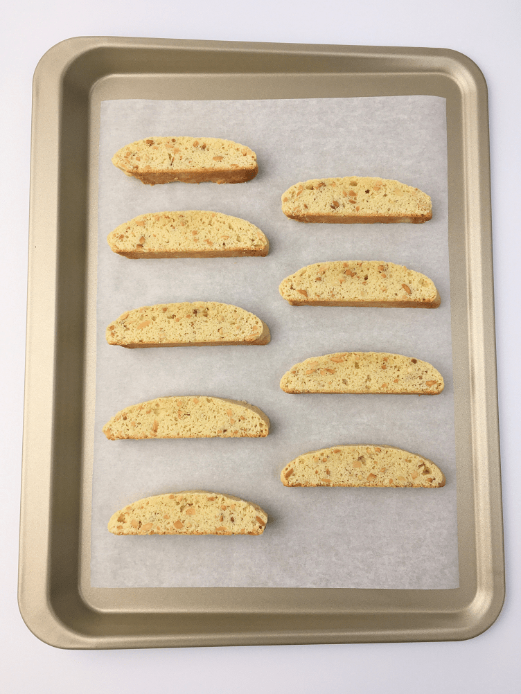 Vanilla almond biscotti cut into slices and arranged on a baking sheet