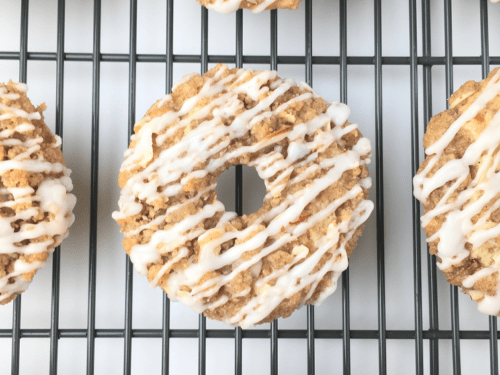 Top view of finished crumb cake donuts on a cooling rack