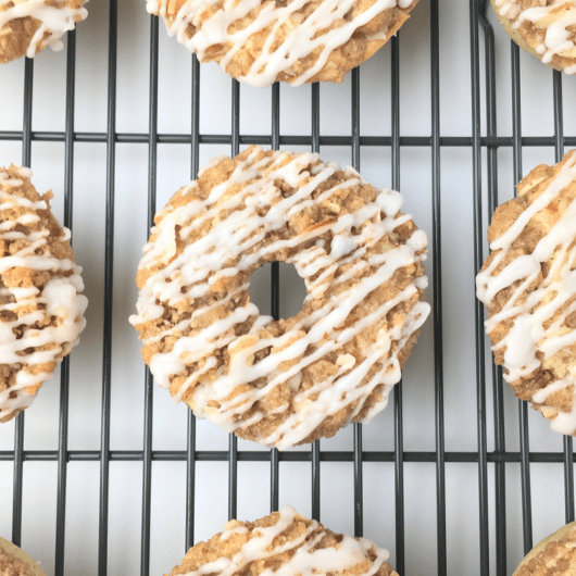 Top view of finished crumb cake donuts on a cooling rack