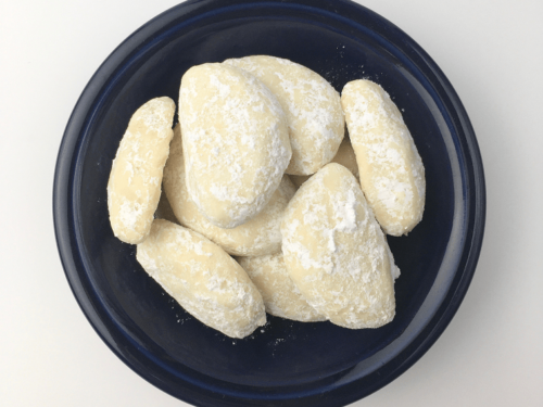 Sugar coated lemon sunshine cookies in a blue bowl