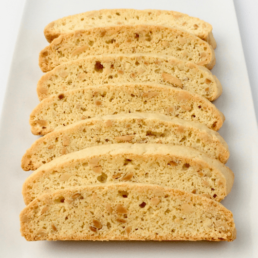 Vanilla almond biscotti arranged in a row on a white plate