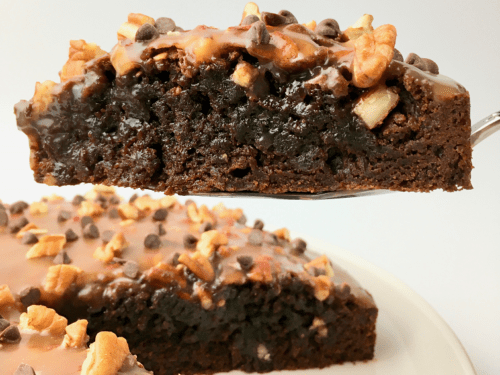 Caramel pecan brownie cake with one slice being served