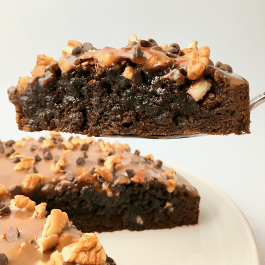 Caramel pecan brownie cake with one slice being served