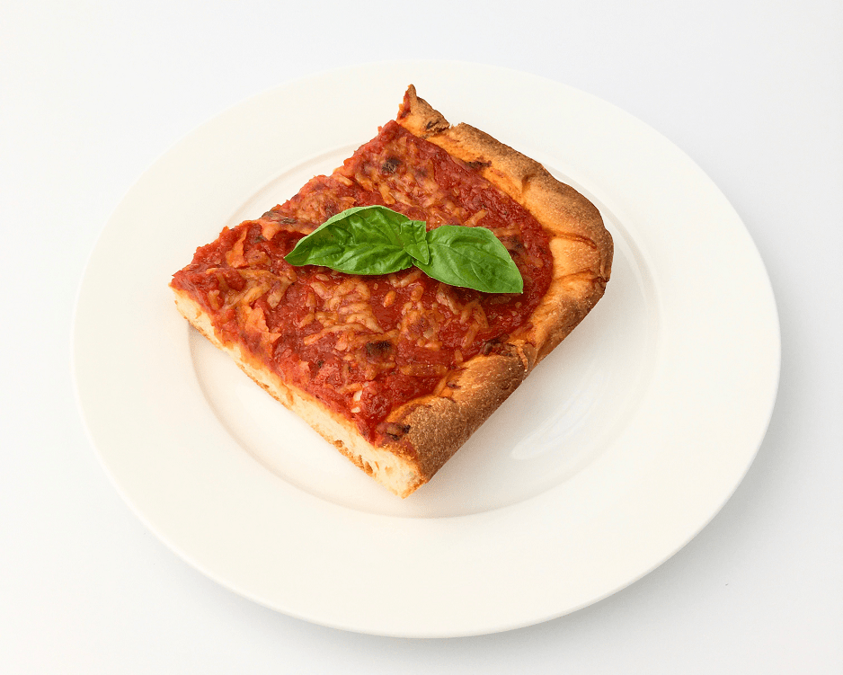 Slice of tomato pie on a white plate garnished with fresh basil