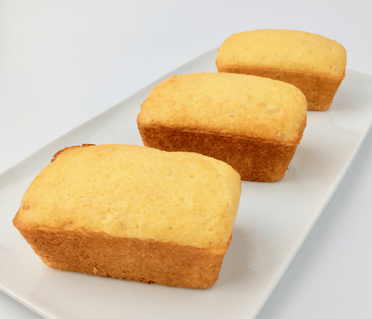 Rows of three sweet cornbread mini loaves on a white plate