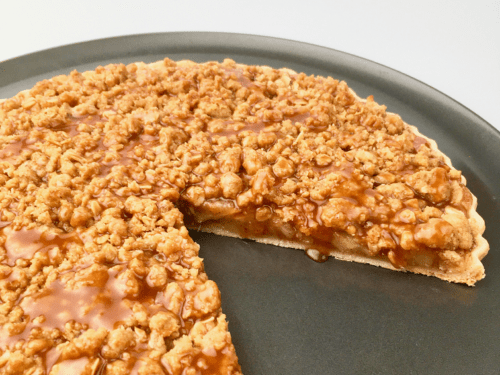 Baked apple pie pizza with one slice removed