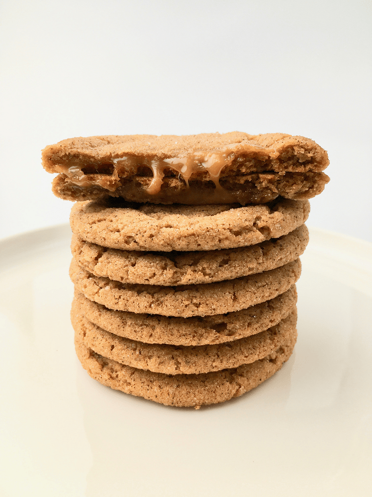 Stack of caramel macchiato cookies with one cut in half to reveal the caramel center