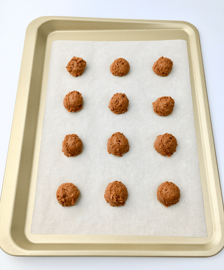 Carrot cake cookie batter scooped onto a baking pan