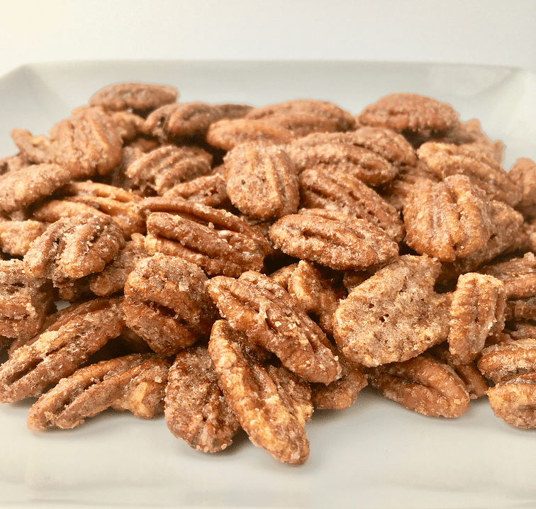 Praline pecans piled up on a white plate