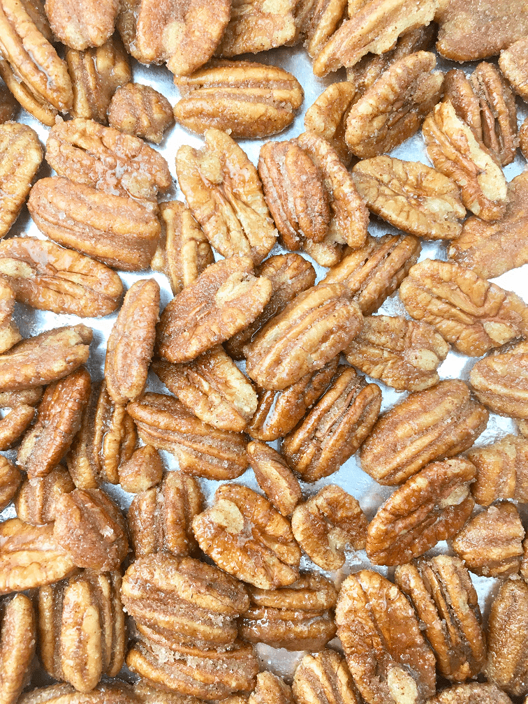 Sugar coated pecans on a foil lined baking pan before baking