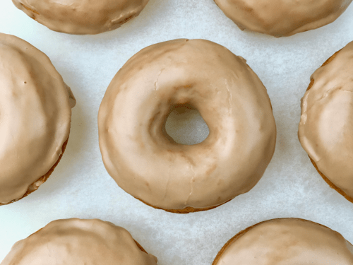 Rows of pumpkin donuts frosted with maple glaze.