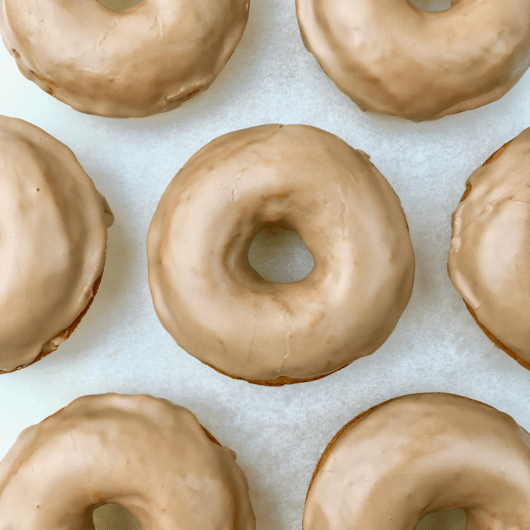 Rows of pumpkin donuts frosted with maple glaze.