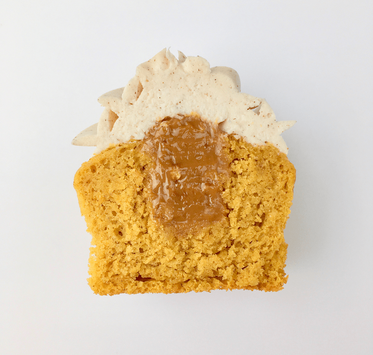 Pumpkin cupcake cut in half with dulce de leche filling