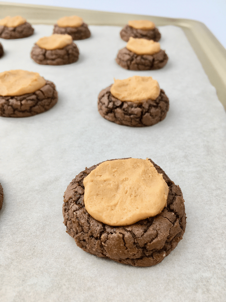 Buckeye cookies on a baking pan topped with peanut butter