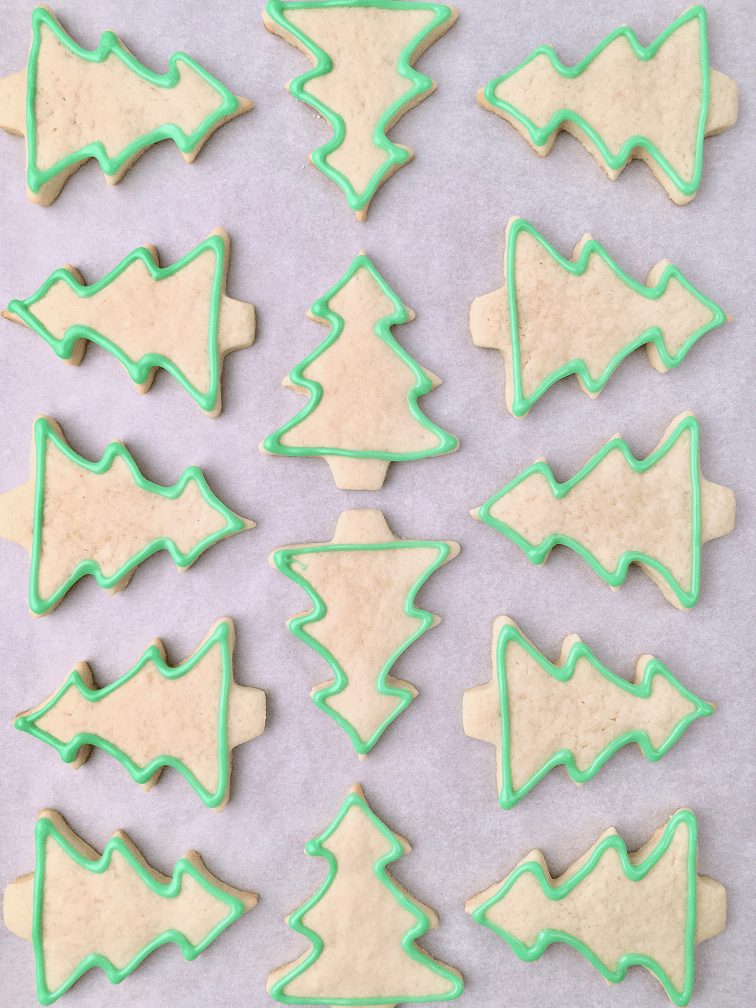 Christmas tree sugar cookies with a piped icing border.