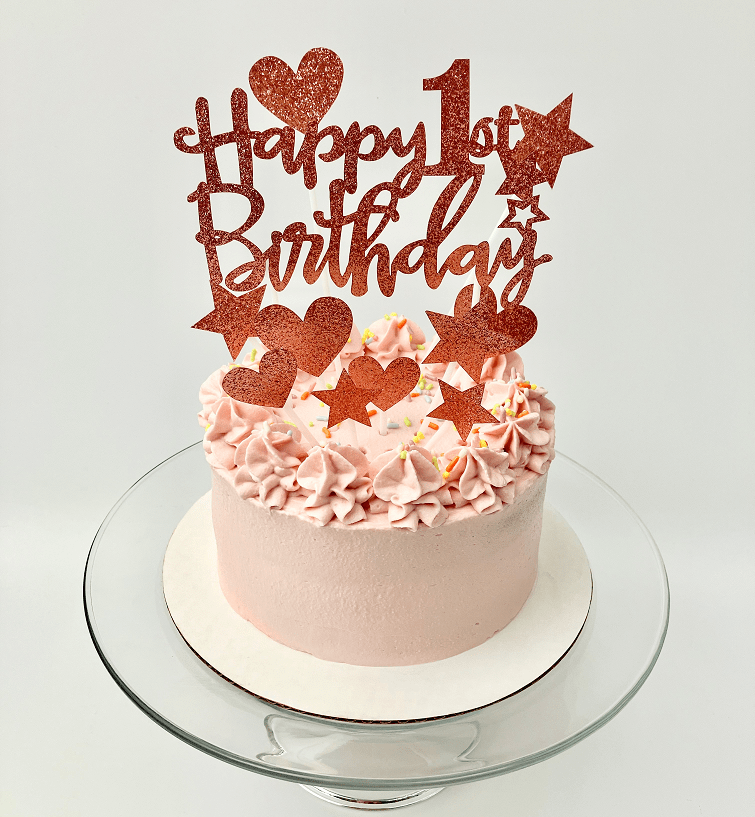 Peanut butter banana pupcake with pink frosting on a glass platter.