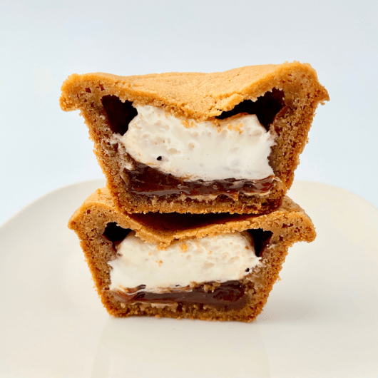 Deep dish smores cookie cut in half with marshmallow and chocolate filling.