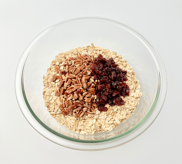 Gingerbread granola ingredients in a glass bowl.