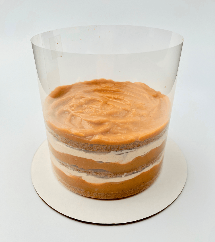 Layering pumpkin pie cake in acetate collar.