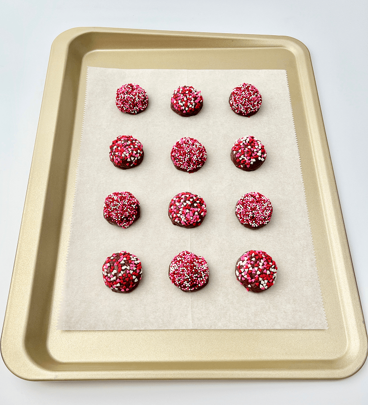 Unbaked strawberry crème brownie cookies on a baking pan.